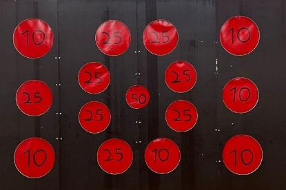 Eine Torwand mit verschieden hohen Punktzahlen verteilt über mehrere Löcher