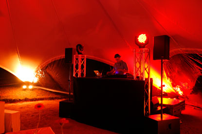 Ein DJ Set mitsamt DJ ist innerhalb eines großen Zelts aufgebaut