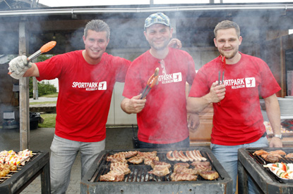 Drei Sportpark Mitarbeiter grillen Fleisch und Gemüse