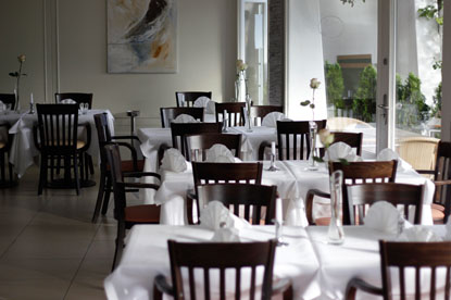 Ein schickes Restaurant hat gedeckte Tische und eine Glasfront.