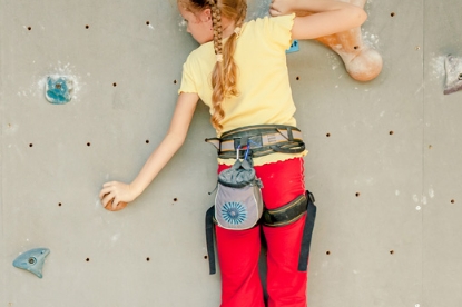 Ein gesichertes Kind klettert an einer Kletterwand hoch
